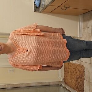 Peach colored short sleeve blouse.